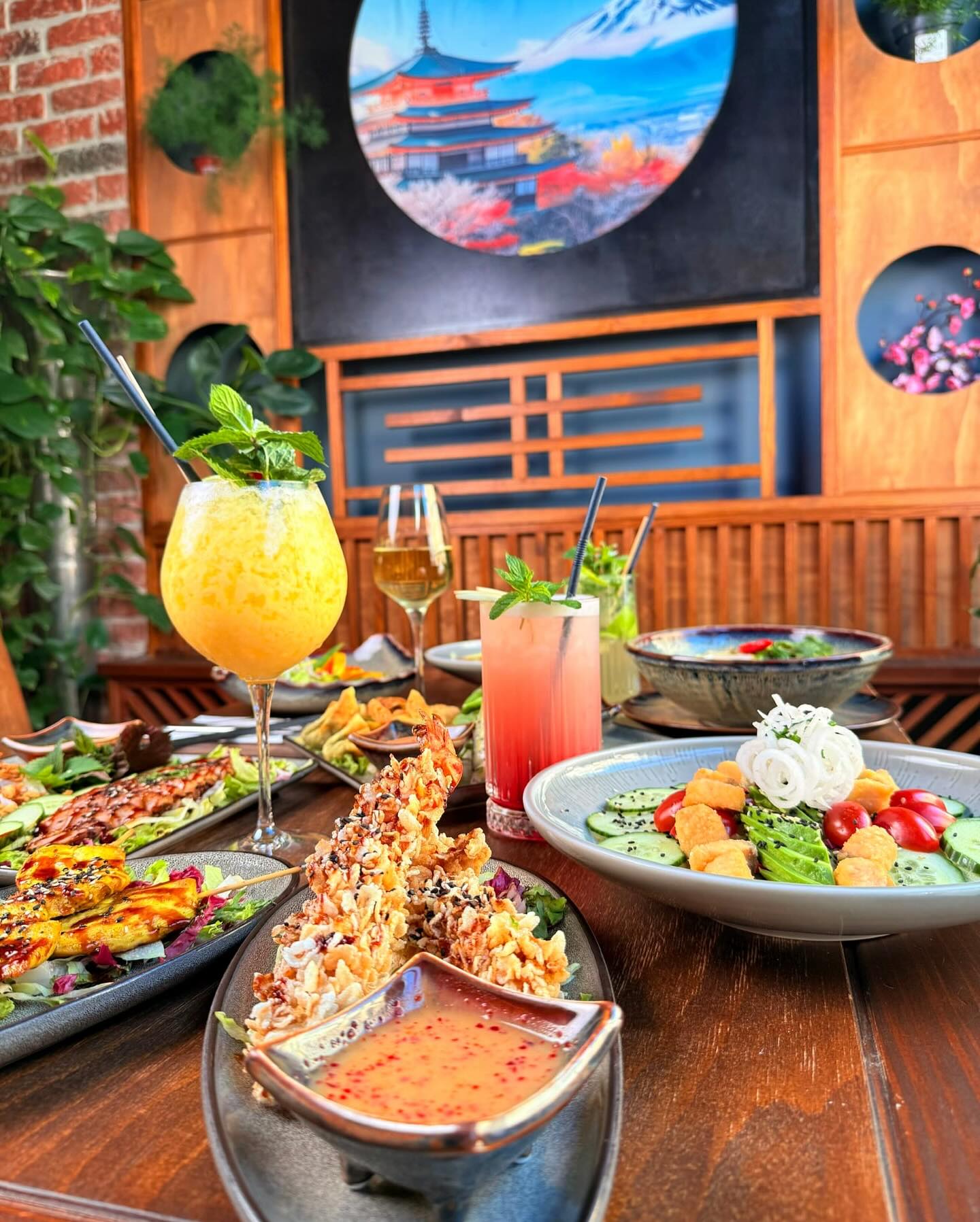 Reich gedeckter Tisch bei Mami Viet Leipzig mit verschiedenen asiatischen Gerichten, Salaten und Cocktails