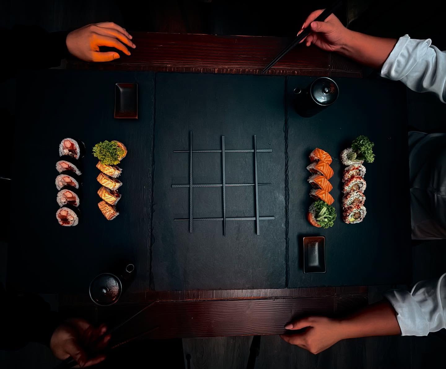 Zwei Personen teilen sich Sushi-Platten mit Maki und Inside-out-Rollen auf Schieferplatten bei Mami Viet Leipzig
